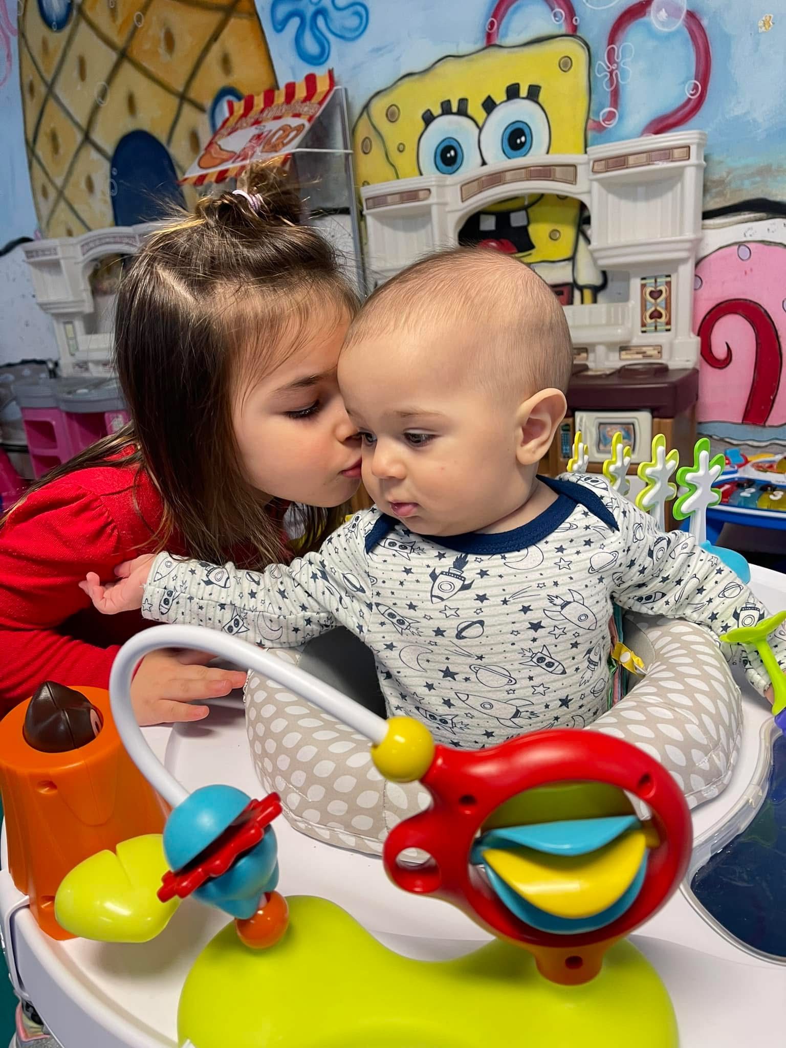 Two children sharing toys during free play in the home daycare